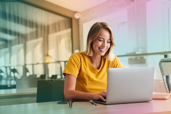 Kvinna vid ett skrivbord med laptop framför sig