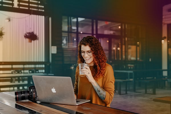 Kvinna med laptop och kaffe på café