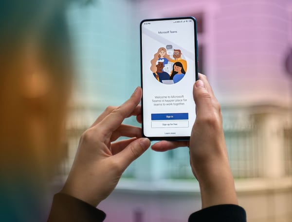 Händer som håller mobil med MS Teams