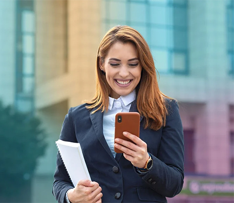 Kvinna ler mot sin mobil