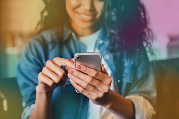 Kvinna håller mobiltelefon