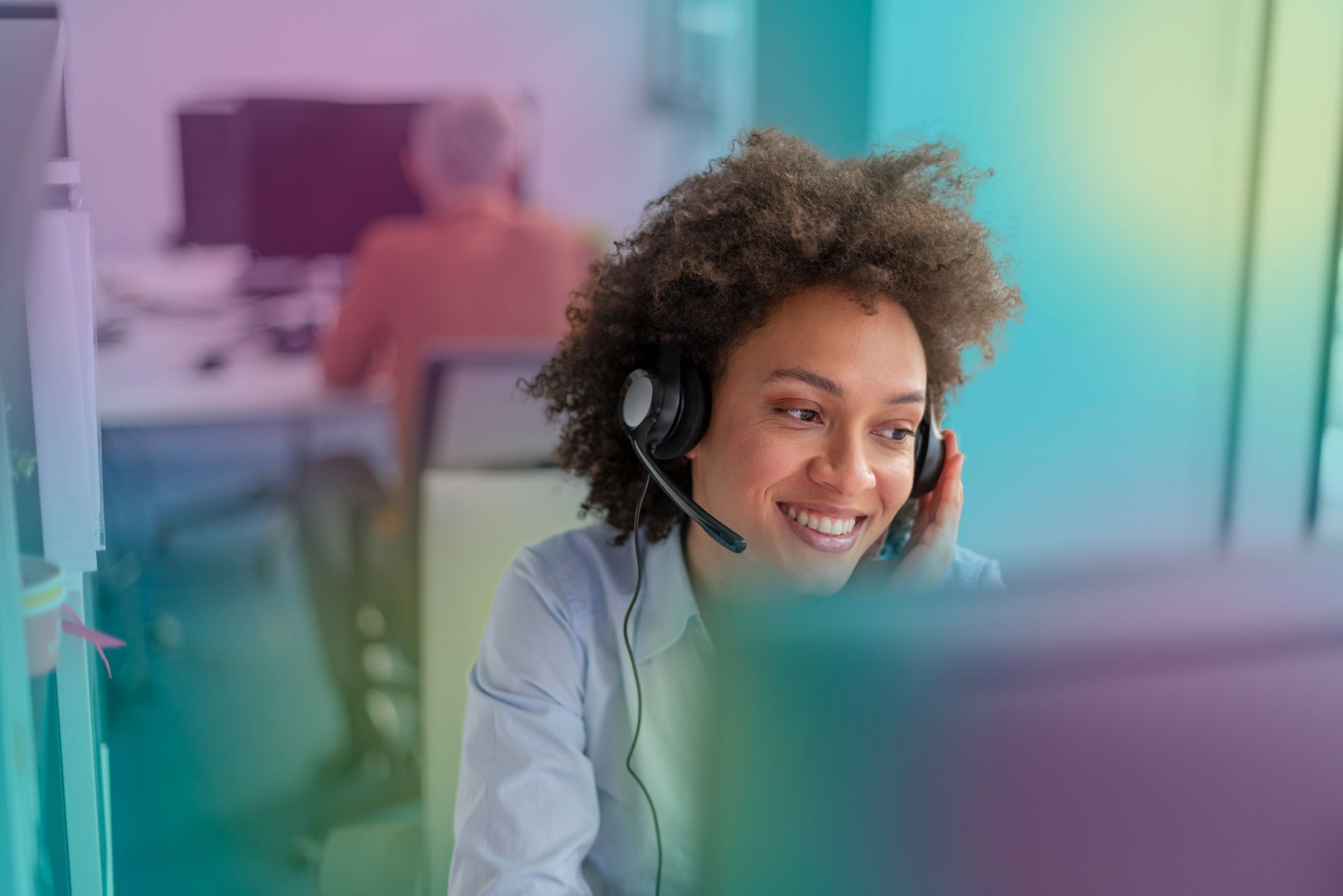 Kvinna med headset framför en datorskörm